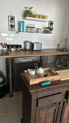 a kitchen with a wooden counter top with pots and pans at Coral Vistas Self Catering Apartments in Gordonʼs Bay