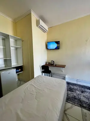 a bedroom with a bed and a desk in it at Kitty Guest House in Bellville