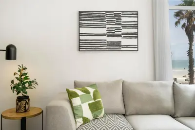 a living room with a couch and a picture of the beach at 14 Cap dAzur by Host Agents in Cape Town