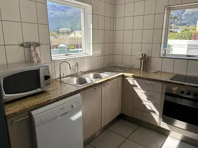 a kitchen with a sink and a microwave at Lemon Tree Cottage a Charming 3 Bedroom Self-catering house in Franschhoek