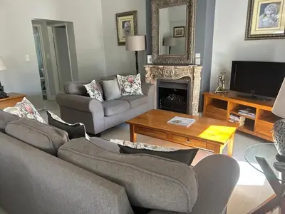 a living room with a couch and a fireplace at Lemon Tree Cottage a Charming 3 Bedroom Self-catering house in Franschhoek