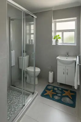 a bathroom with a shower and a toilet and a sink at Pinelands Apartment in Cape Town