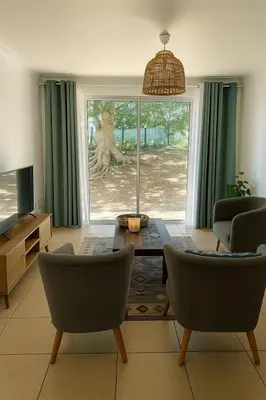 a living room with a table and two chairs at Pinelands Apartment in Cape Town