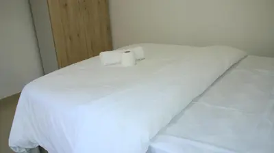 a white bed with a candle on top of it at Gift Guest house 2 in Cravenby