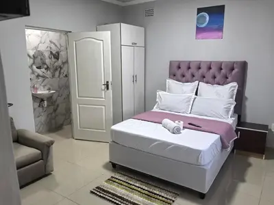 a bedroom with a bed and a chair and a door at Gift Guest house 1 in Cravenby