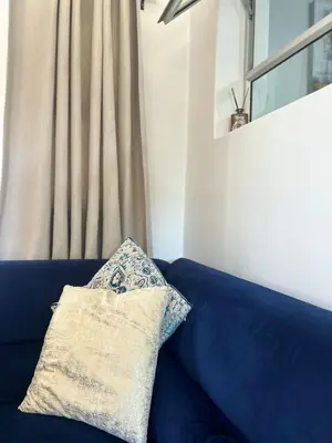 a blue couch with a pillow on top of it at Cottage in Cape Town