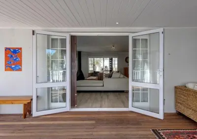 a living room with a sliding glass door at Beachcomber's Rest in Hermanus