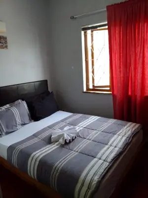 a bed in a bedroom with a red curtain at At-home Oakdale Bellville in Bellville