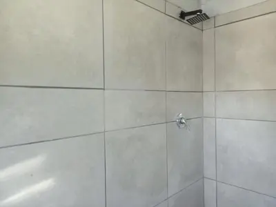 a bathroom with a shower with white tiles at At-home Oakdale Bellville in Bellville