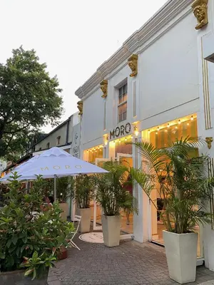 a cafe with an umbrella and plants in front of a building at Studio 5 at Huis Piron in Stellenbosch