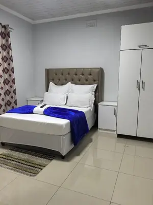 a white bedroom with a large bed with a blue blanket at Gift Guest house 3 in Cravenby