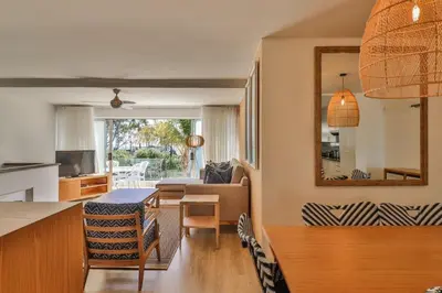 a living room with a table and a mirror at Gordonia Unit 9 Gordons Bay in Gordonʼs Bay