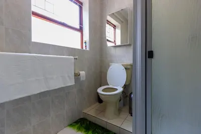 a bathroom with a toilet and a window at Winelands Escape in Durbanville
