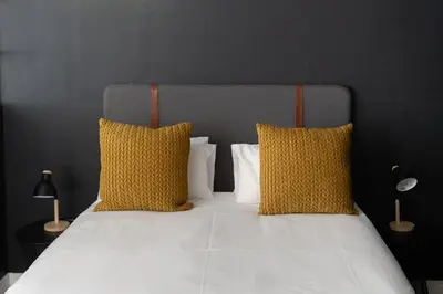 a bedroom with a bed with two yellow pillows at Apartment Paradys - Serviced in Stellenbosch