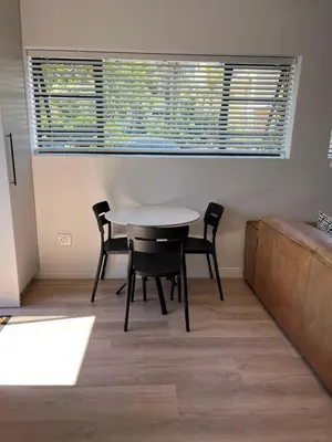 a table and chairs in a room with a window at Apartment Paradys - Serviced in Stellenbosch