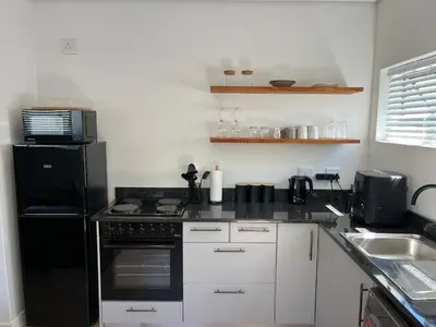 a kitchen with a black refrigerator and a sink at Apartment Paradys - Serviced in Stellenbosch