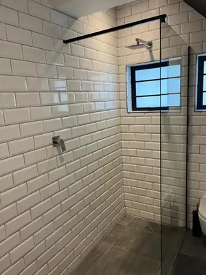 a bathroom with a glass shower with a window at Apartment Paradys - Serviced in Stellenbosch