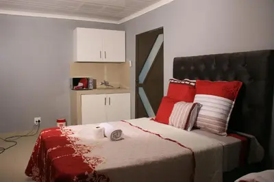 a bedroom with a bed with red pillows at Gift guest house 4 in Cravenby