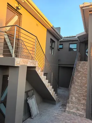 a stairway of a house with a yellow and gray building at Gift guest house 4 in Cravenby