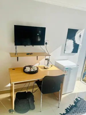 a desk with a television and a chair in a room at Hideaway Haven in Cape Town