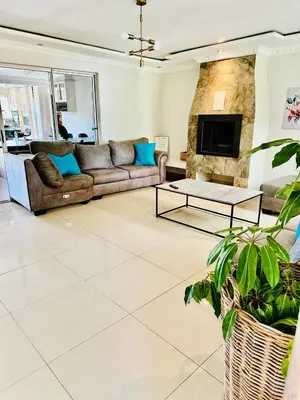 a living room with a couch and a fireplace at Hideaway Haven in Cape Town