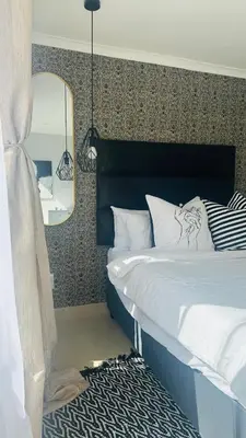 a bedroom with a bed and a mirror at Hideaway Haven in Cape Town