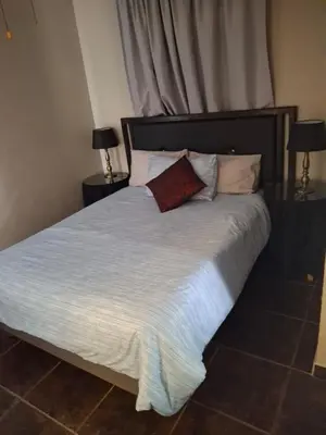 a bedroom with a large bed with white sheets and pillows at Timeless at Rusticana in Klapmuts