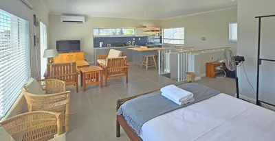 a living room with a bed and a kitchen at Cape Town Studio Apartment in Cape Town