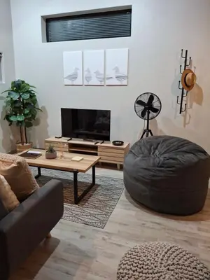 a living room with a couch and a table at Nature's Nest in Bettyʼs Bay