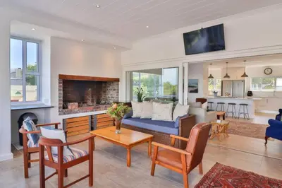 a living room with a couch and a fireplace at Vonkelwyn - enjoy Grotto Beach sunsets in Hermanus