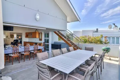a dining area with a table and chairs on a patio at Vonkelwyn - enjoy Grotto Beach sunsets in Hermanus