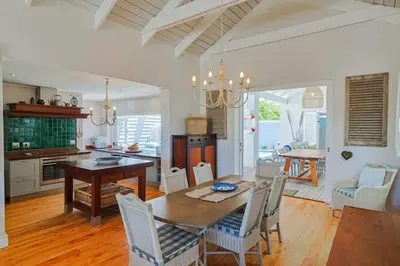 a kitchen and dining room with a table and chairs at Nautilus on Grotto Beach - heated pool in Hermanus