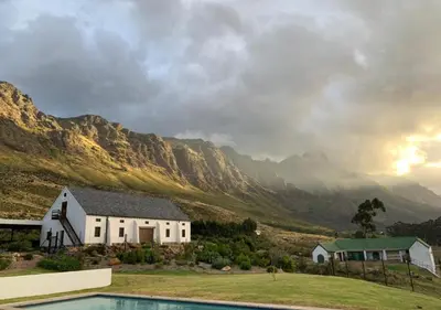 a house with a pool in front of a mountain at Wildeberg Elephants Trail Cottage in Franschhoek
