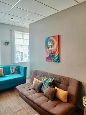 a living room with a couch and a painting on the wall at Melk Tert - Paarl - Self Catering Apartment in Paarl