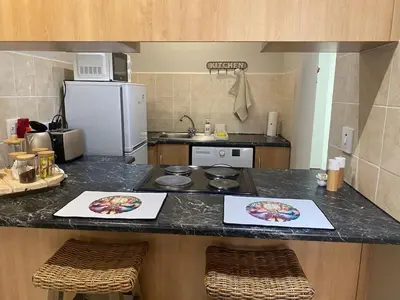 a kitchen with a counter with two pictures on it at Melk Tert - Paarl - Self Catering Apartment in Paarl