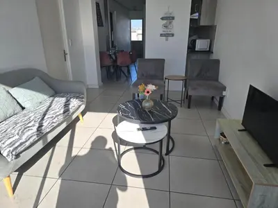a living room with a couch and a table at Sunset at Keys in Cape Town