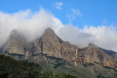 a mountain with some clouds on top of it at La Vita Farm Stay in Wellington
