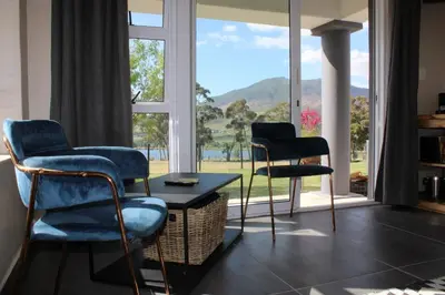 two chairs and a table in front of a window at La Vita Farm Stay in Wellington
