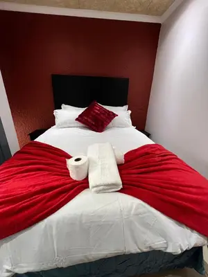 a bed with two rolls of towels on it at Our Home Guest House in Bellville