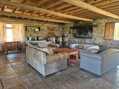 a living room with two couches and a table at Avondrood Mountain House in Rawsonville