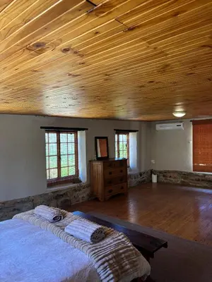 a bedroom with a bed and a wooden ceiling at Avondrood Mountain House in Rawsonville