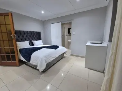 a bedroom with a large bed and a bathroom at Maglovir Economy in Tiervlei