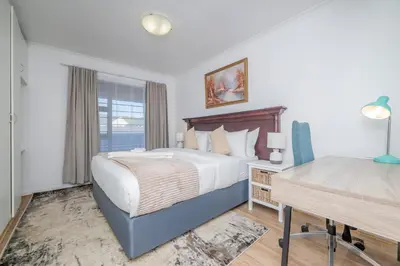 a bedroom with a large bed and a desk at Prime Apartments in Richwood