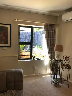 a living room with a couch and a window at Charming Self-Catering Apartment in Tygerberg Hills