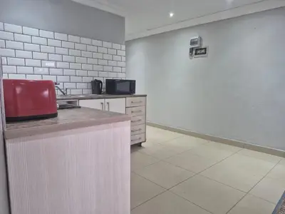a kitchen with a red appliance on a wall at Maglovir Economy in Tiervlei
