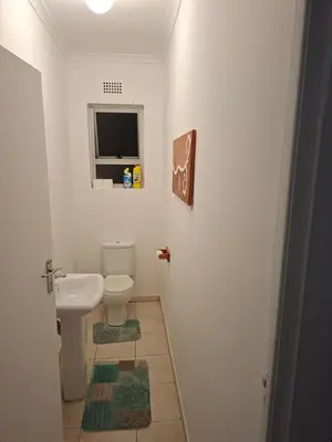 a bathroom with a toilet and a window at Leigh's home with dogs in Cape Town