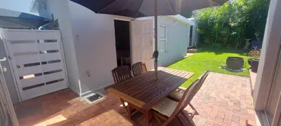 a wooden table with an umbrella on a patio at Amanda's Place in Hermanus