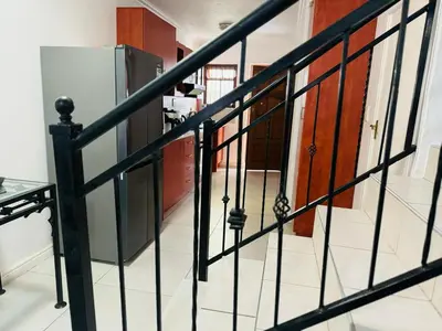 a staircase with black railings in a house at Self catering accommodation in Cape Town