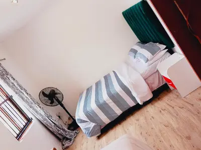 a bedroom with a bed and a lamp on the floor at Self catering accommodation in Cape Town