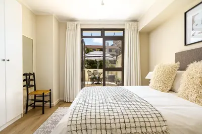 a bedroom with a large bed and a balcony at Canal Front Apartment Cape Town in Cape Town